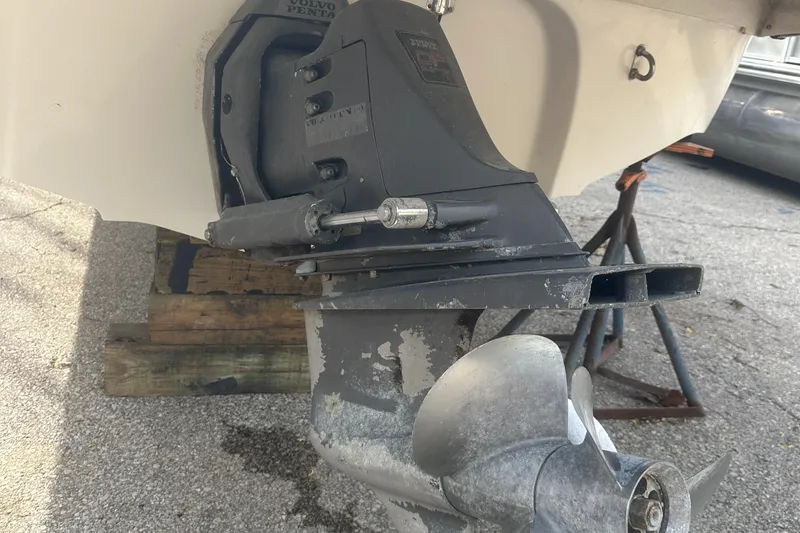 Slide: The Image of 2004 Monterey 253 Explorer Sport boat outdrive on a stand, showing propeller and lower unit. - 13