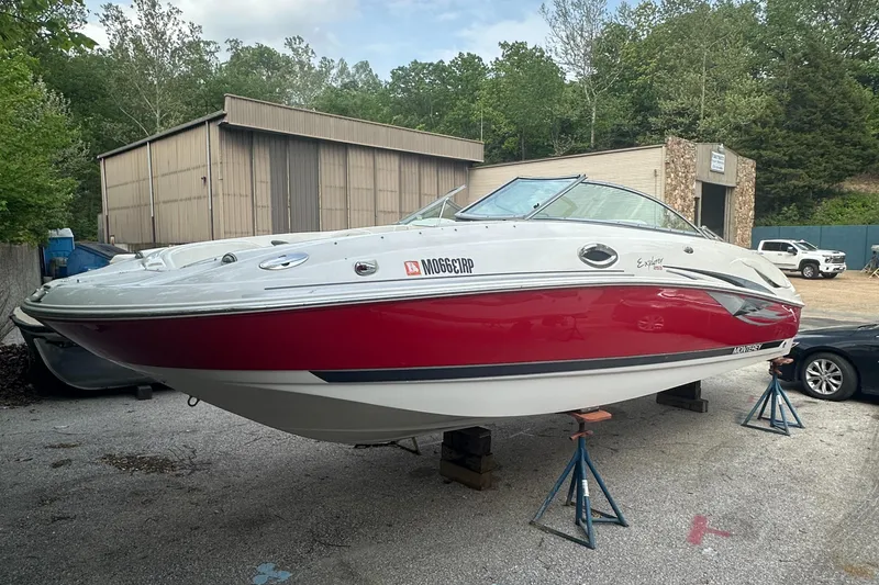 Slide: The Image of 2004 Monterey 253 Explorer Sport boat on stands, red and white design, outdoor setting. - 2
