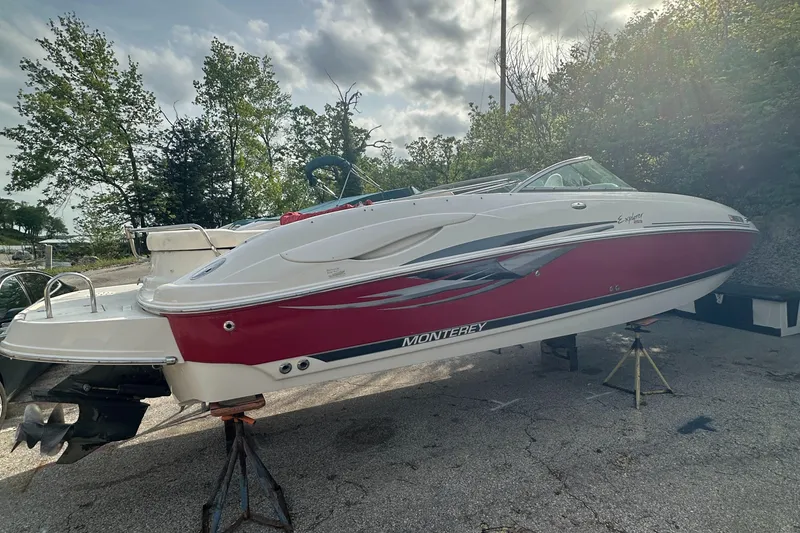Slide: The Image of 2004 Monterey 253 Explorer Sport boat on stands, red and white design, outdoors. - 3