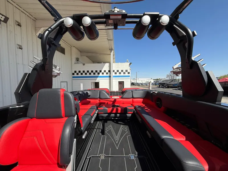 Slide: The Image of 2021 Supra SL boat interior with red and black seating, tower speakers, and sleek design. - 10