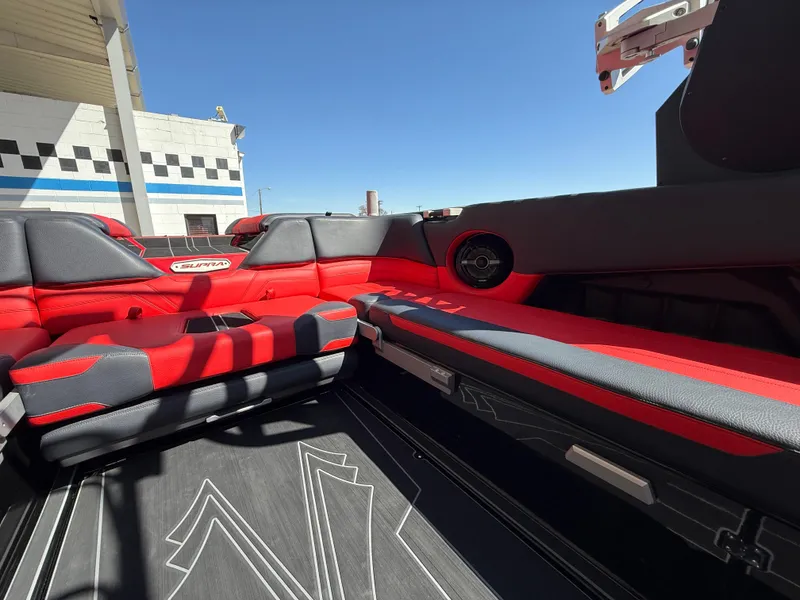 Slide: The Image of 2021 Supra SL boat interior with red and black seating, modern design, and outdoor setting. - 12