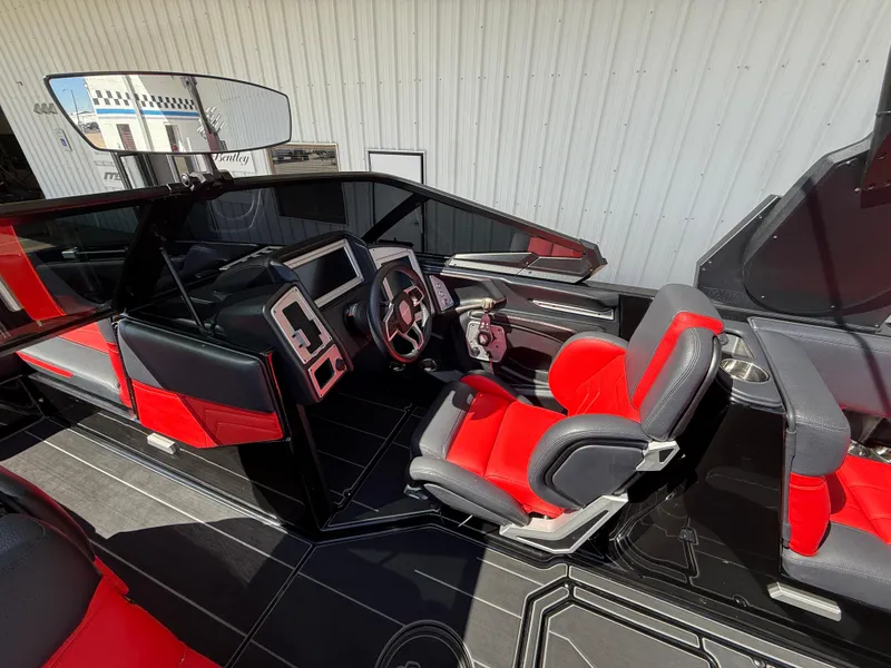 Slide: The Image of 2021 Supra SL boat interior with red and black seating, modern dashboard, and steering wheel. - 13