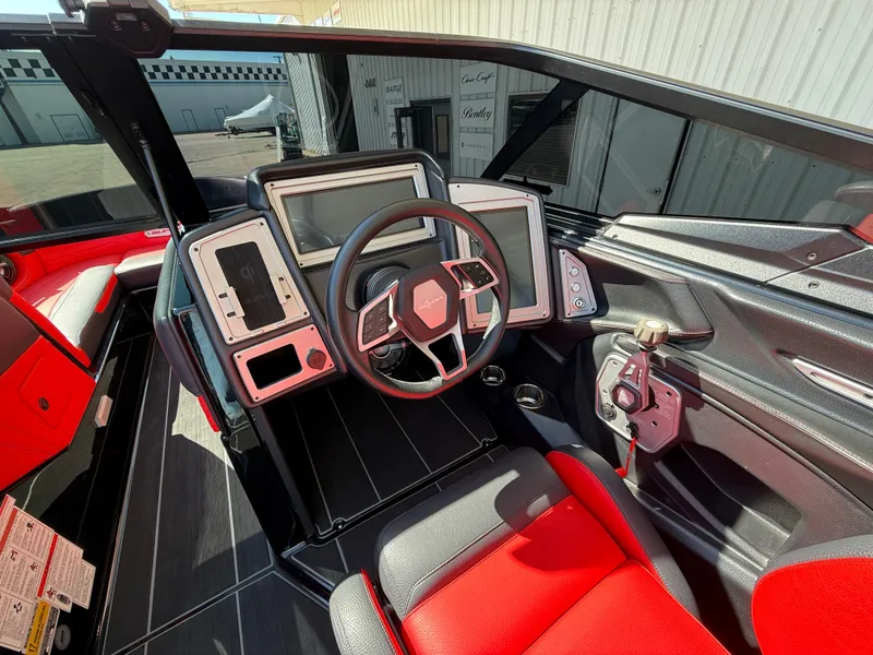 Slide: The Image of 2021 Supra SL boat cockpit with modern steering, dual screens, and red-black seating. - 14