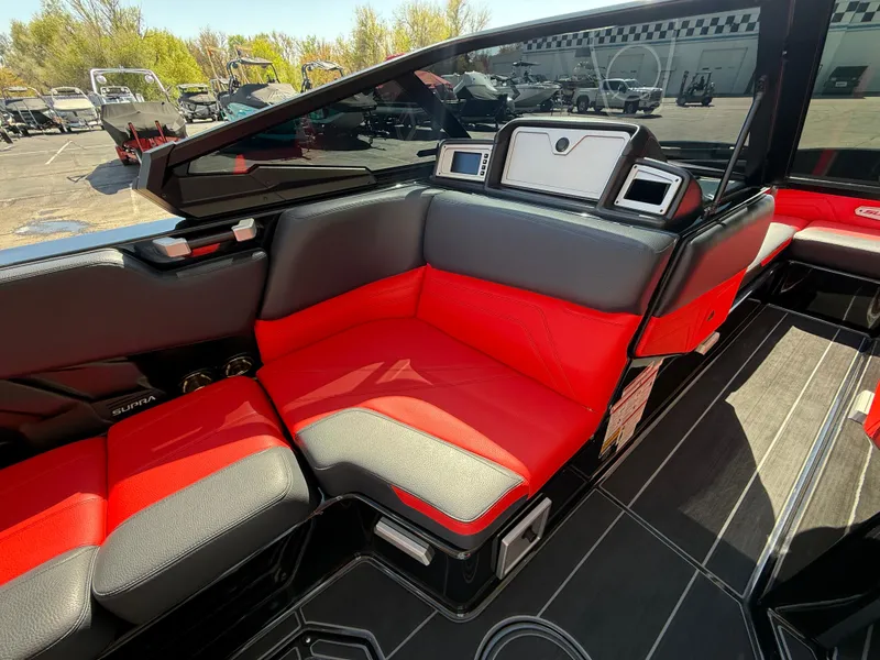 Slide: The Image of 2021 Supra SL boat interior with red and black seating, modern dashboard, and sleek design. - 15