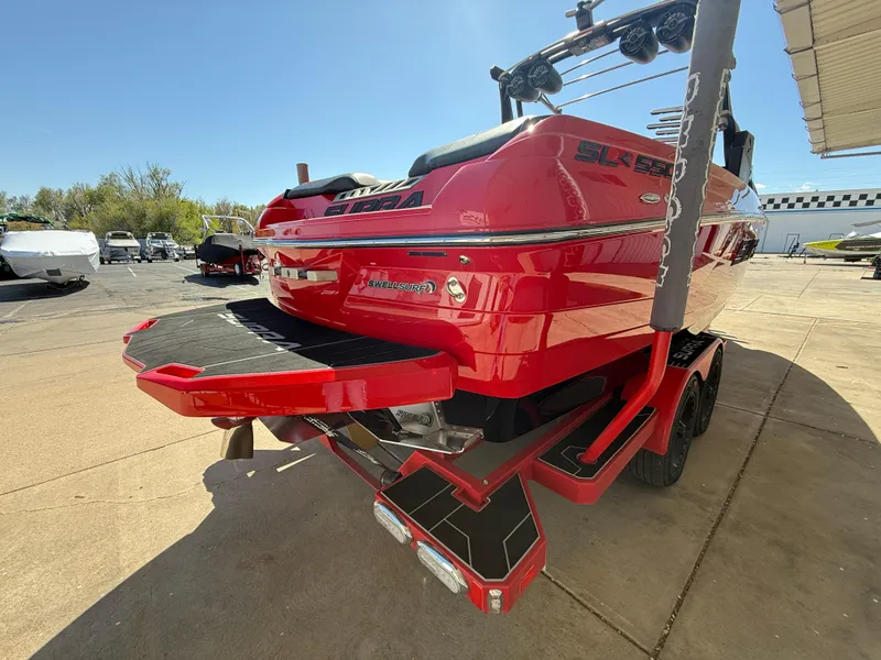 Slide: The Image of 2021 Supra SL boat, red, parked on trailer, rear view, sunny day. - 6
