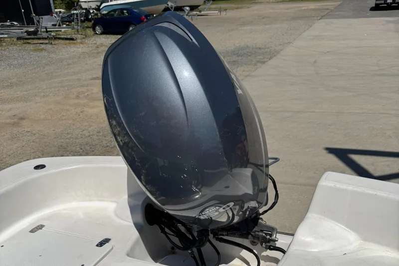 Slide: The Image of Outboard motor on 2010 Carolina Skiff 218 DLV Elite boat, parked on concrete. - 10