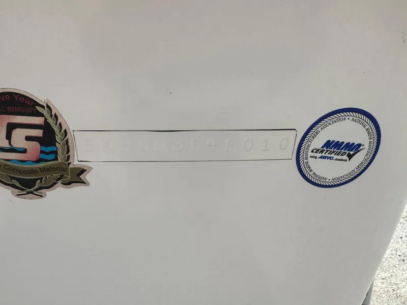 Slide: The Image of 2010 Carolina Skiff 218 DLV Elite boat with certification stickers on the hull. - 2