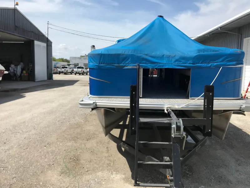 Slide: The Image of 2019 Avalon Venture Quad Lounge pontoon with blue cover in a storage area. - 6