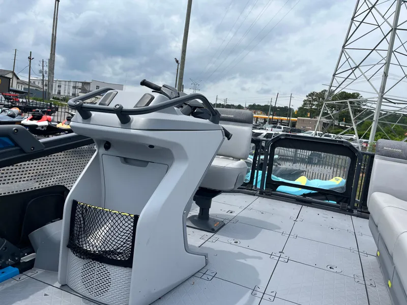 Slide: The Image of 2023 Sea-Doo Switch Compact interior with steering console and seating, under cloudy sky. - 5