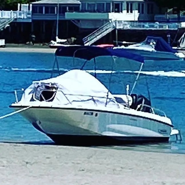 Slide: The Image of 2014 Boston Whaler 170 Dauntless boat anchored on a sandy beach with waterfront homes. - 5