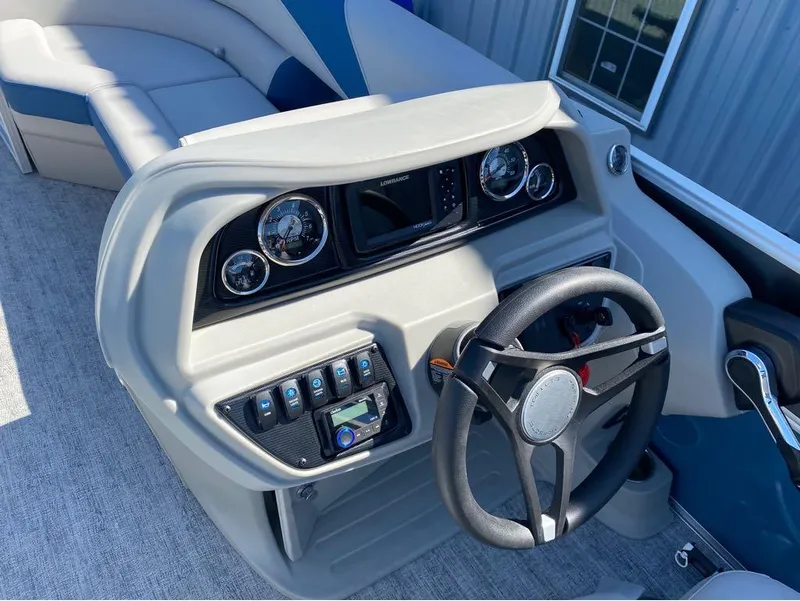 Slide: The Image of 2024 Trifecta 24 RF LE 2.75 boat dashboard with steering wheel and control panel. - 6