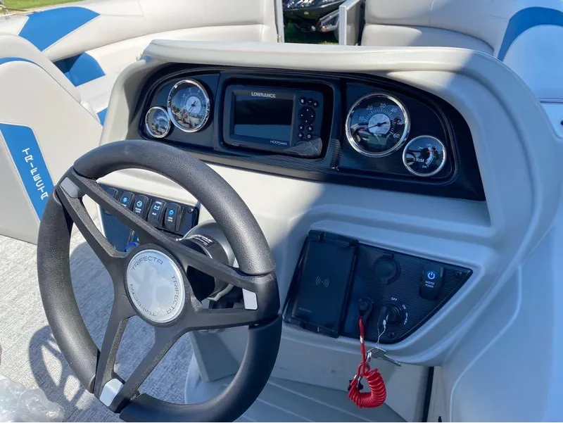 Slide: The Image of 2024 Trifecta 24 RF LE 2.75 boat dashboard with steering wheel and control panel. - 7