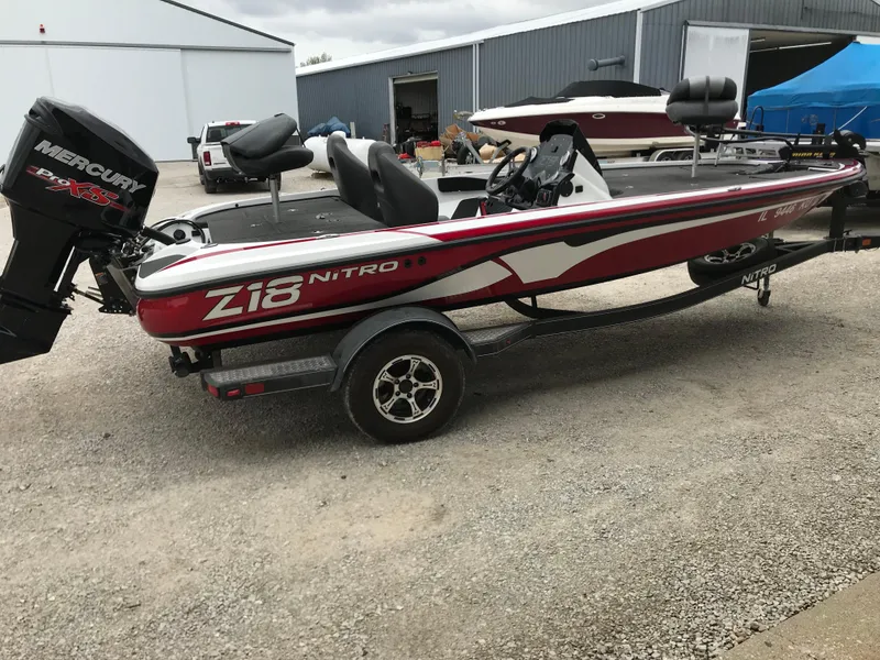 Slide: The Image of 2017 Nitro Z18 boat with Mercury engine on trailer, parked outdoors. - 1