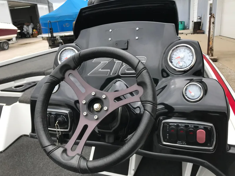 Slide: The Image of Steering wheel and dashboard of a 2017 Nitro Z18 boat, featuring gauges and controls. - 14