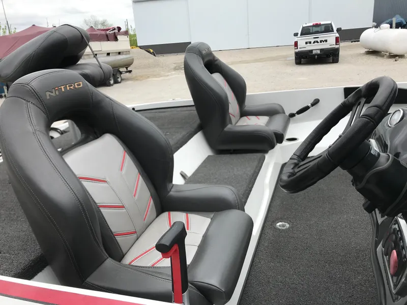 Slide: The Image of 2017 Nitro Z18 boat interior with two black and gray seats, steering wheel, and carpeted floor. - 15