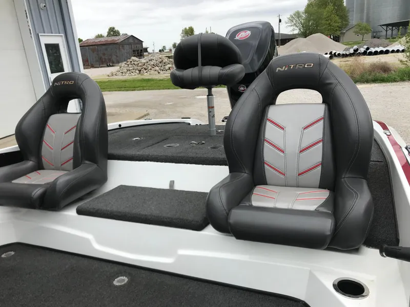 Slide: The Image of 2017 Nitro Z18 boat seats with gray and red accents, outdoor setting. - 22