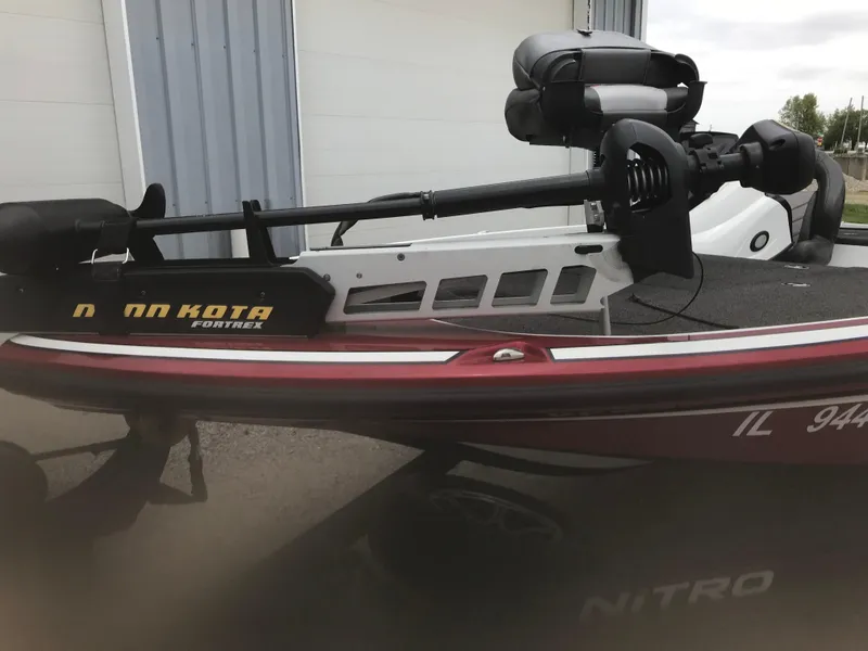 Slide: The Image of 2017 Nitro Z18 boat with Minn Kota Fortrex trolling motor, parked near a building. - 24
