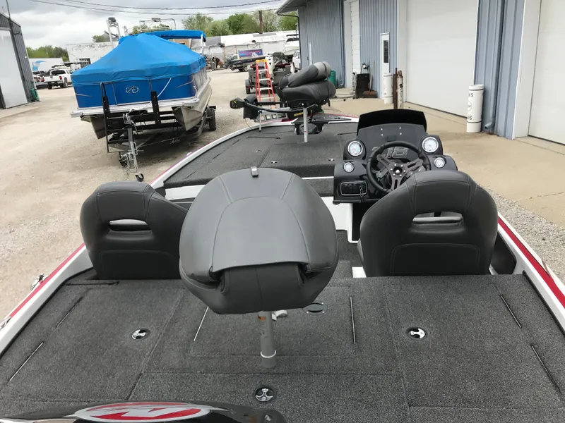 Slide: The Image of 2017 Nitro Z18 boat interior with seating and control panel, parked near other boats. - 6