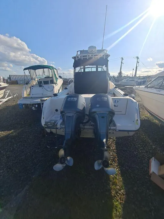 Slide: The Image of 1991 Grady-White 280 Marlin boat with dual outboard motors, parked outdoors under a sunny sky. - 3