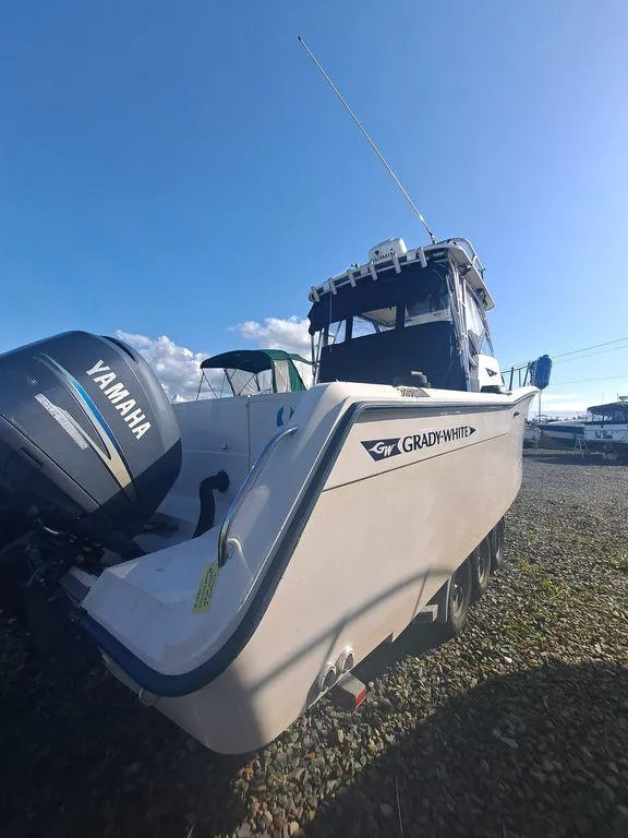 Slide: The Image of 1991 Grady-White 280 Marlin boat with Yamaha outboard motor, parked on gravel. - 4