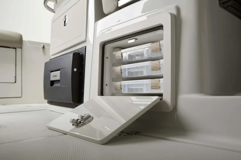 Slide: The Image of 2025 Finseeker 260 DC boat storage compartment with open hatch and organized trays. - 14