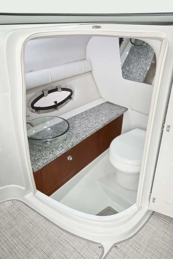 Slide: The Image of 2025 Crownline 260 XSS boat interior with modern bathroom, featuring a toilet and sleek countertop. - 3