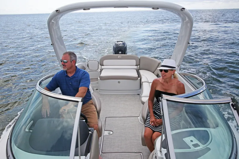 Slide: The Image of 2025 Crownline 290 XSS boat with two passengers enjoying a sunny day on the water. - 7