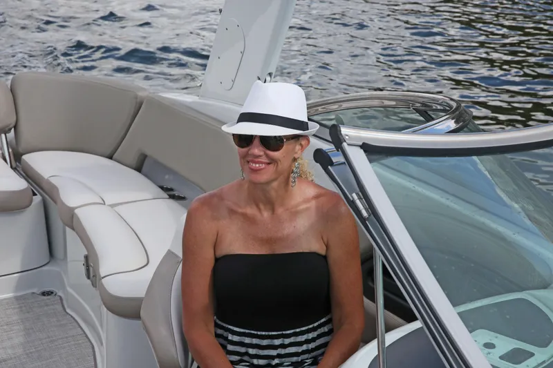 Slide: The Image of Woman relaxing on a 2025 Crownline 290 XSS boat, wearing a hat and sunglasses. - 9
