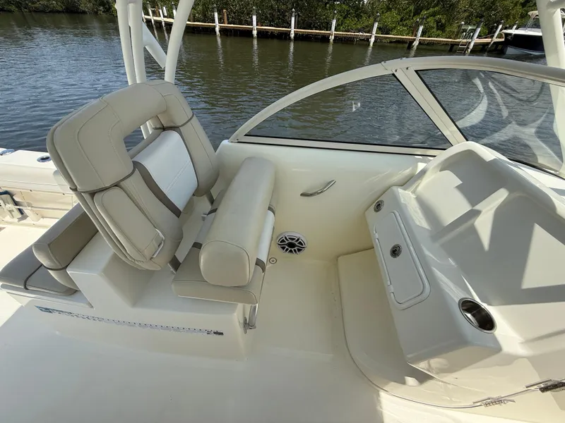 Slide: The Image of 2015 World Cat 255 DC boat interior with seating and console, near water. - 14