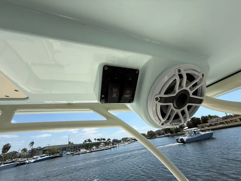 Slide: The Image of 2015 World Cat 255 DC boat interior with speaker and control panel, overlooking marina. - 16