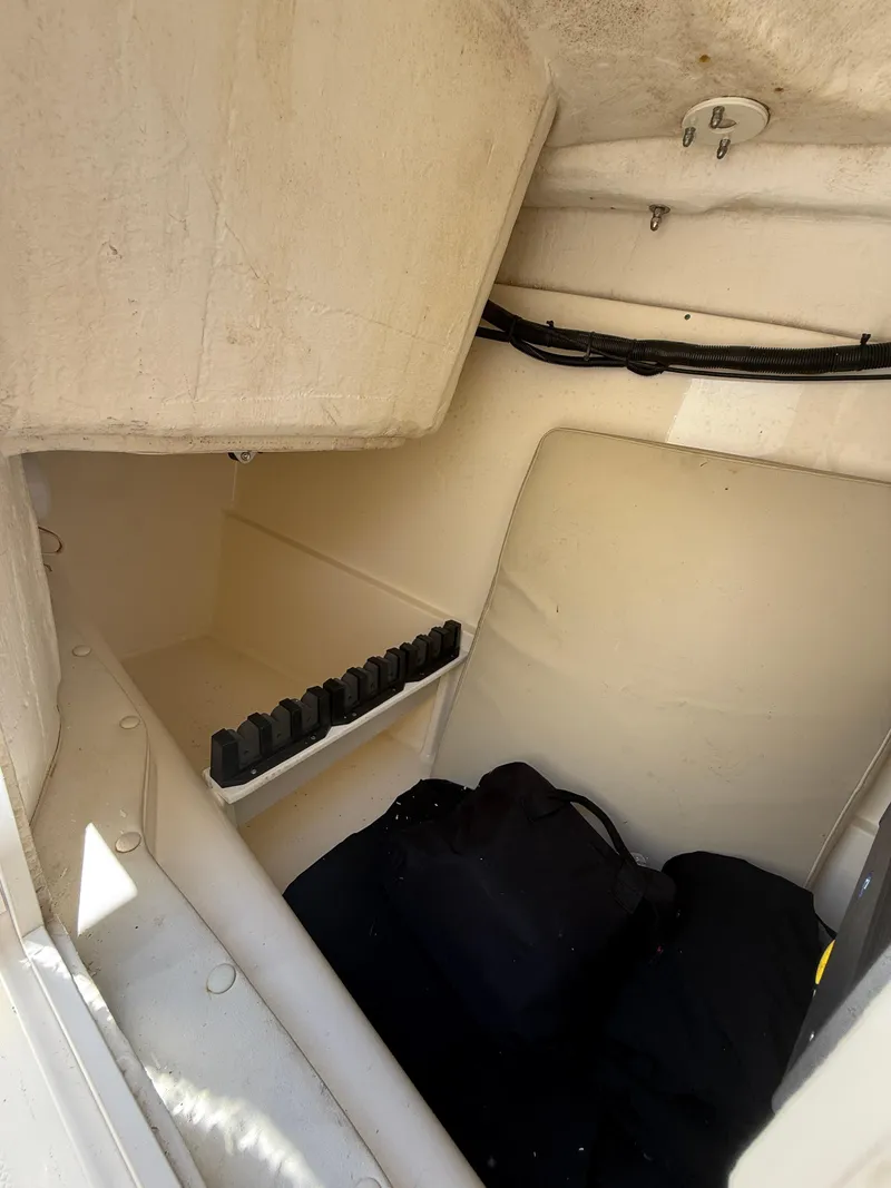 Slide: The Image of 2015 World Cat 255 DC interior storage compartment with rod holders and gear. - 18