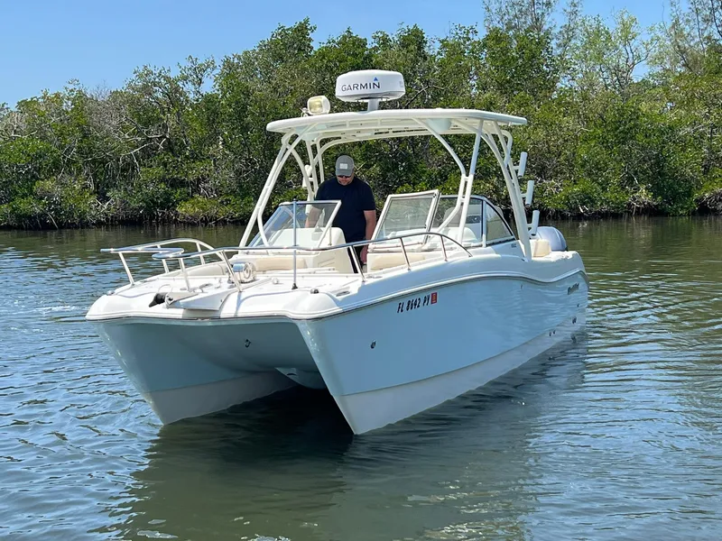Slide: The Image of 2015 World Cat 255 DC boat on calm water, surrounded by lush greenery. - 3