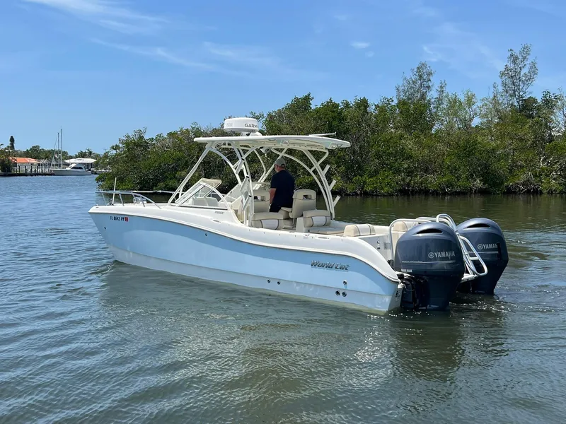 Slide: The Image of 2015 World Cat 255 DC boat with dual Yamaha engines on a calm waterway. - 5