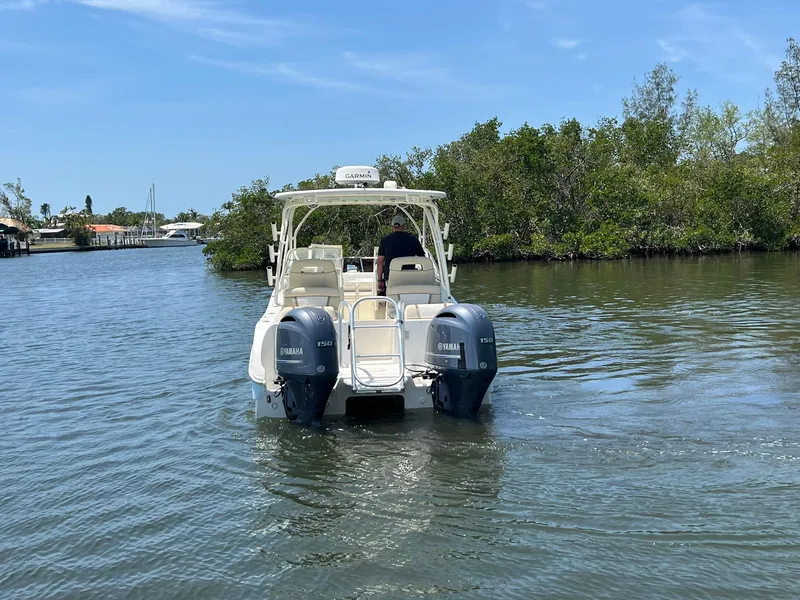 Slide: The Image of 2015 World Cat 255 DC boat cruising on a calm river with twin Yamaha engines. - 6