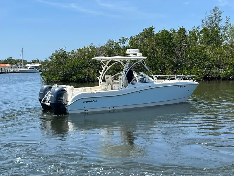 Slide: The Image of 2015 World Cat 255 DC boat on calm water near lush greenery. - 8