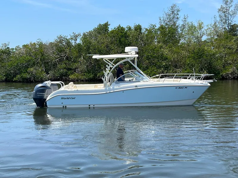 Slide: The Image of 2015 World Cat 255 DC boat on calm water near lush greenery. - 9