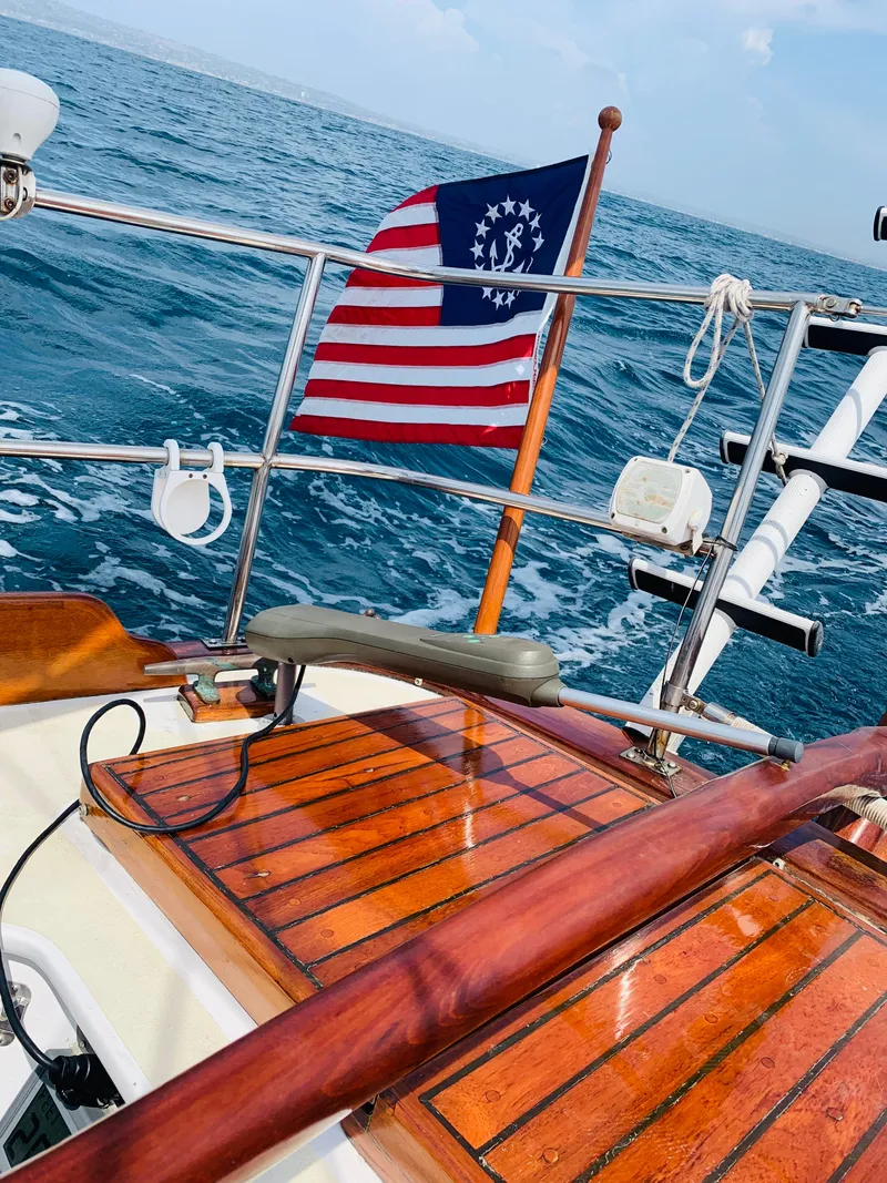 Slide: The Image of Vintage 1988 Custom Aft Cockpit sailboat with historical American flag on open sea. - 11