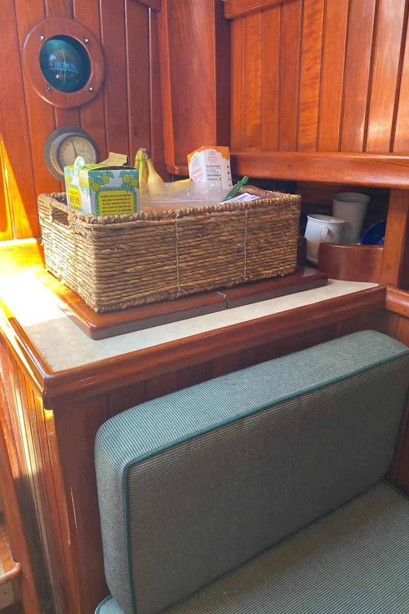 Slide: The Image of 1988 Custom Aft Cockpit interior with wooden paneling, wicker basket, and cushioned seating. - 13