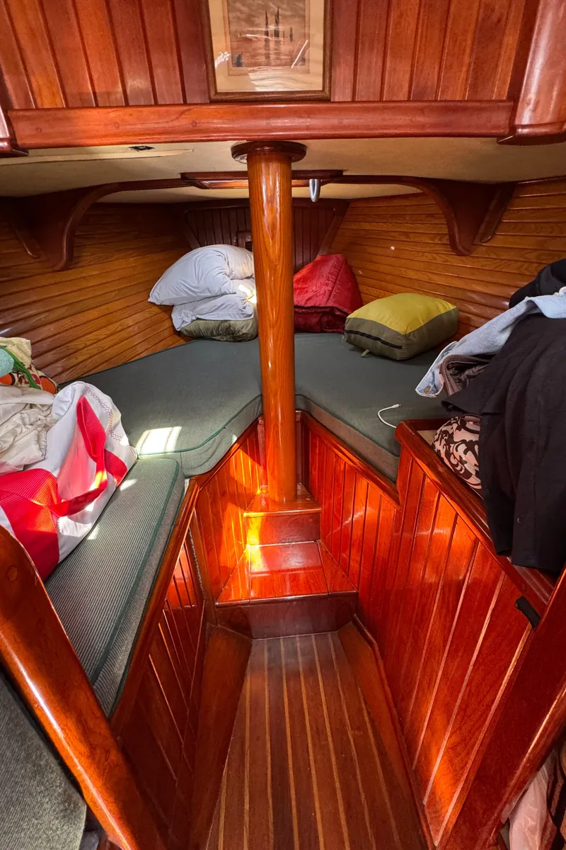 Slide: The Image of Cozy 1988 Custom Aft Cockpit boat interior with wooden paneling and cushioned seating. - 19