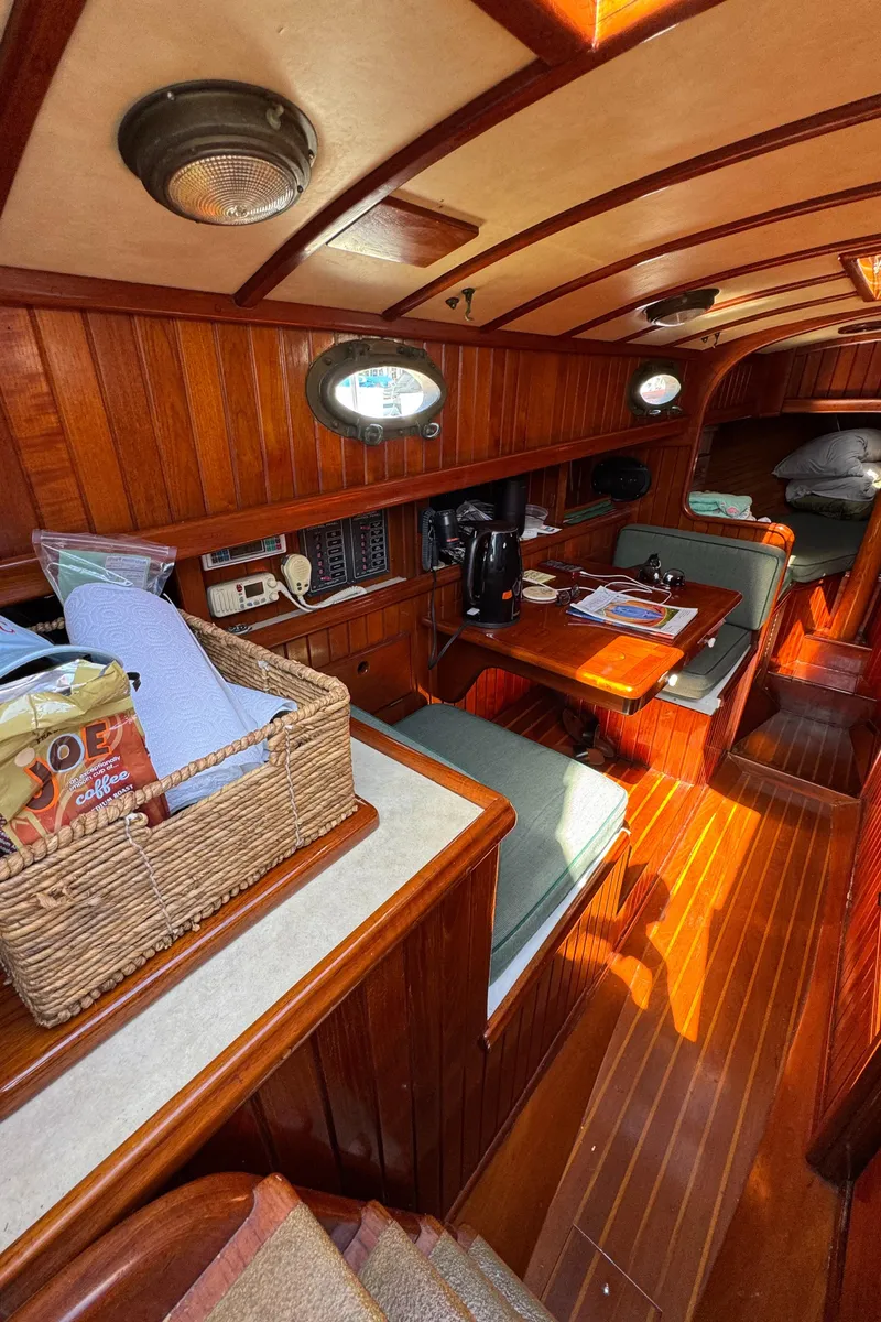 Slide: The Image of 1988 Custom Aft Cockpit interior with wooden finish, seating area, and nautical decor. - 21