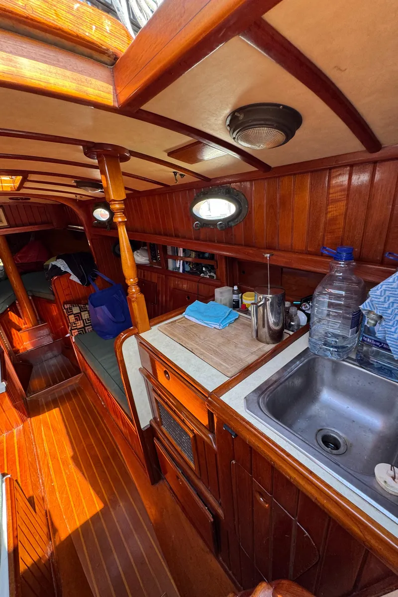 Slide: The Image of Interior of 1988 Custom Aft Cockpit boat with wooden finish and compact kitchen area. - 22