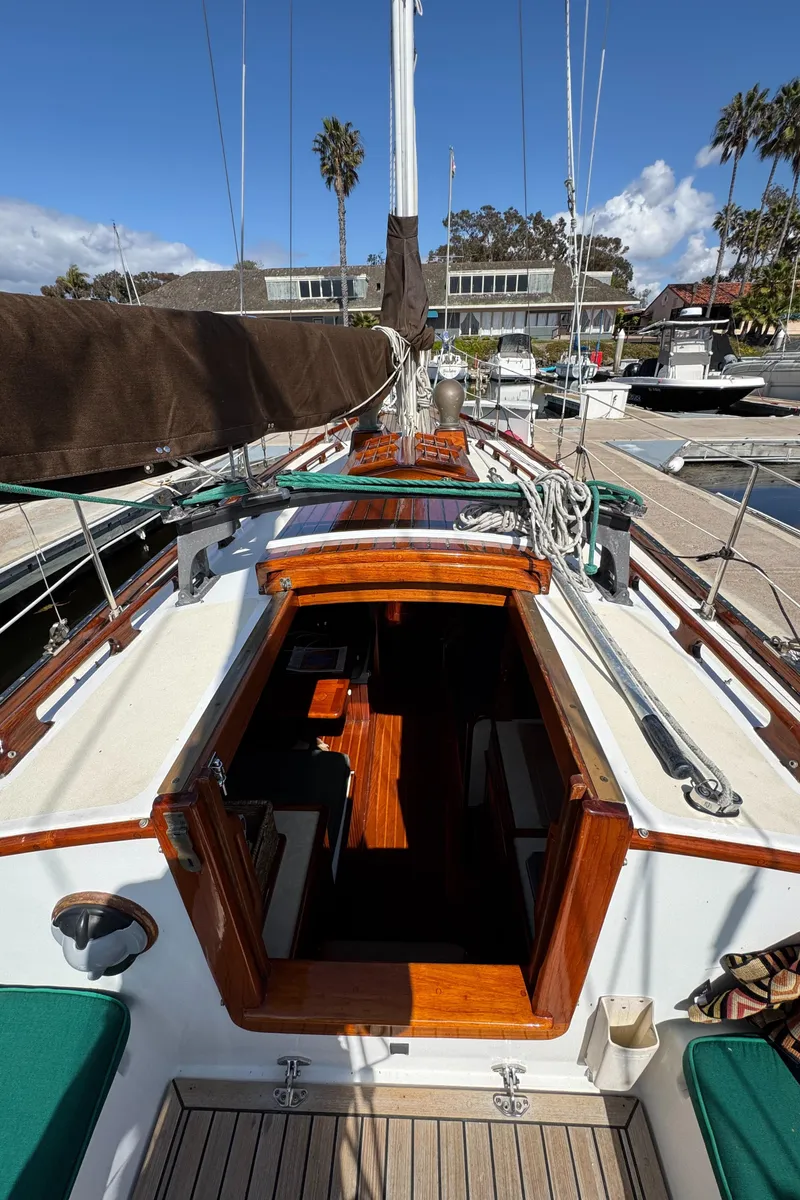 Slide: The Image of 1988 Custom Aft Cockpit sailboat with wooden accents docked at a marina. - 24