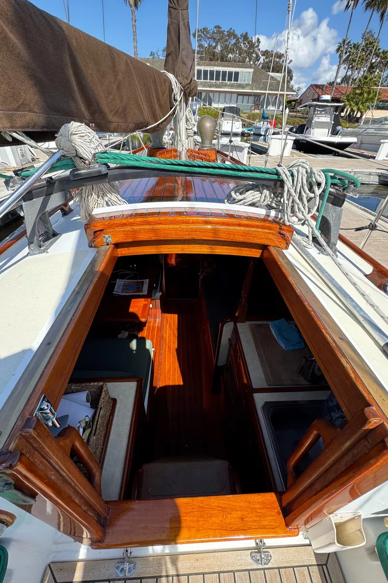 Slide: The Image of 1988 Custom Aft Cockpit sailboat interior with wooden finish, docked at marina. - 27