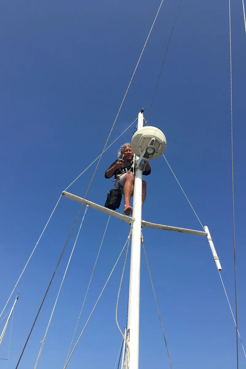 Slide: The Image of Person atop 1988 Custom Aft Cockpit sailboat mast under clear blue sky. - 4