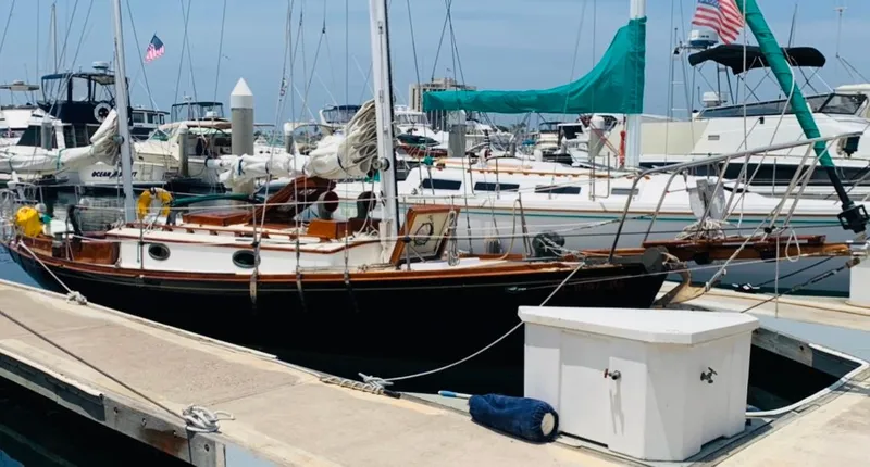 Slide: The Image of Vintage 1988 Custom Aft Cockpit sailboat docked at a marina with other boats. - 5