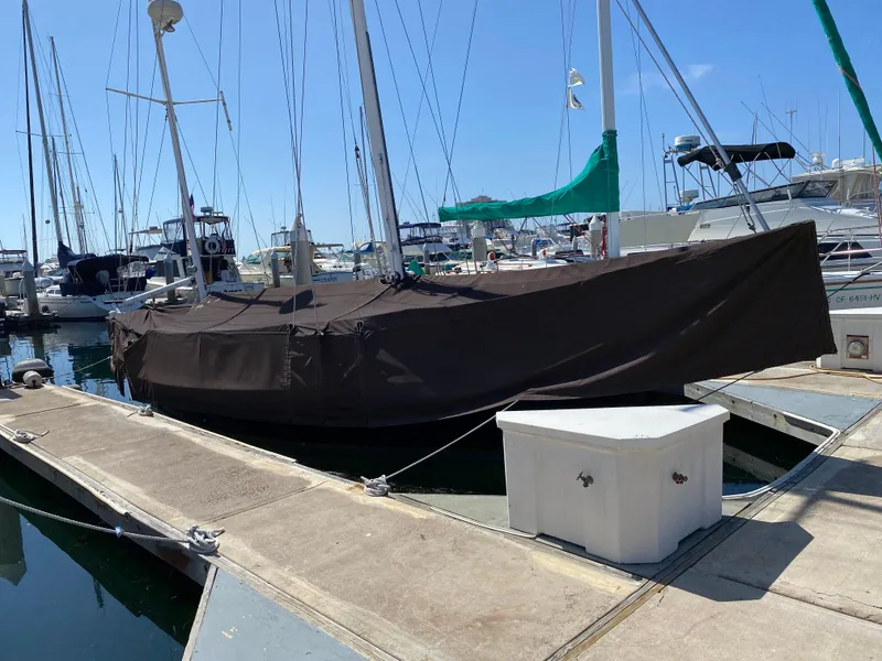Slide: The Image of Covered 1988 Custom Aft Cockpit sailboat docked at marina under clear blue sky. - 6