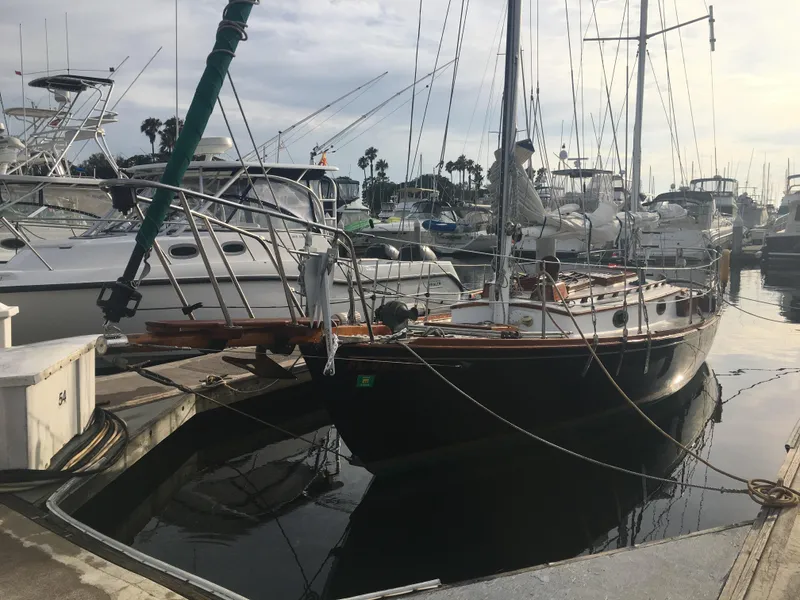 Slide: The Image of 1988 Custom Aft Cockpit sailboat docked in a marina, surrounded by other boats. - 7