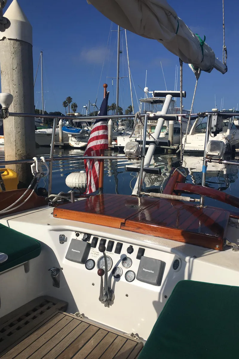 Slide: The Image of 1988 Custom Aft Cockpit sailboat with American flag, docked in marina. - 8