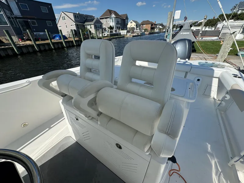 Slide: The Image of 2011 Everglades 325 Center Console boat with white seating, docked near waterfront homes. - 11