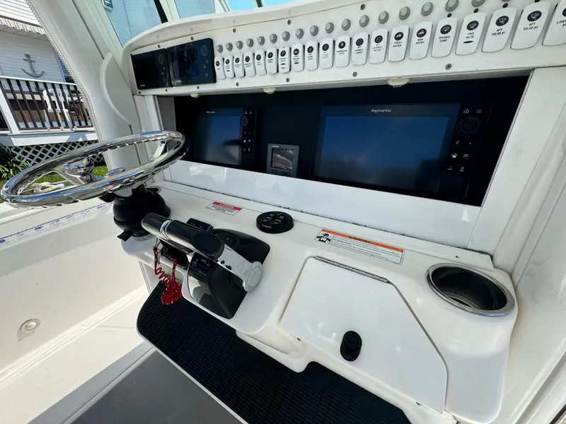 Slide: The Image of 2011 Everglades 325 Center Console dashboard with steering wheel and navigation screens. - 13